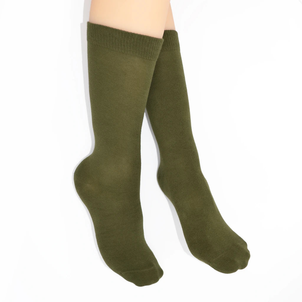Legs modelling green socks on a white background