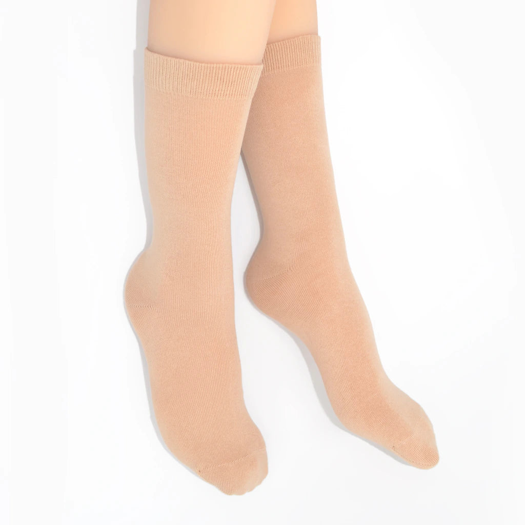 Legs modelling nude socks on a white background