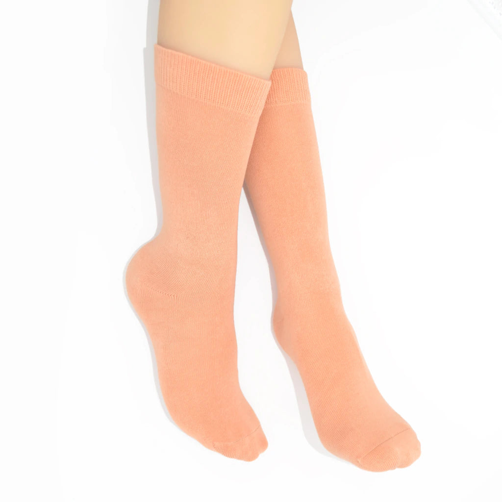 Legs modelling caramel coloured socks on a white background