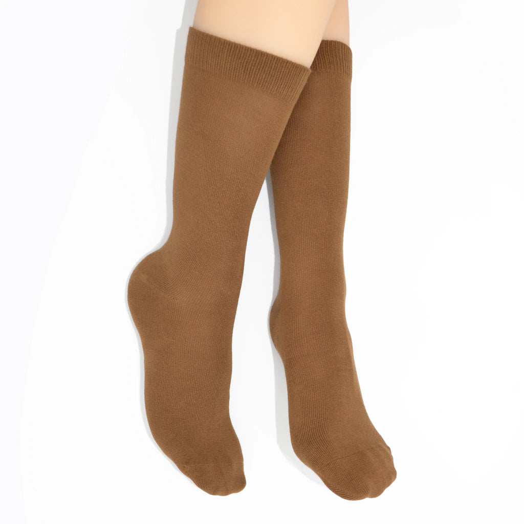 Legs modelling brown socks on a white background