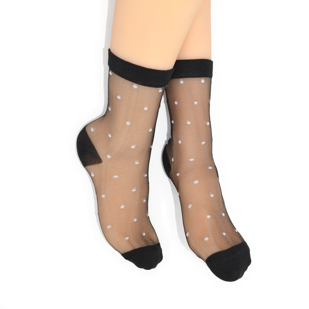 Sheer black polka dot socks with black toes and cuffs on a white background