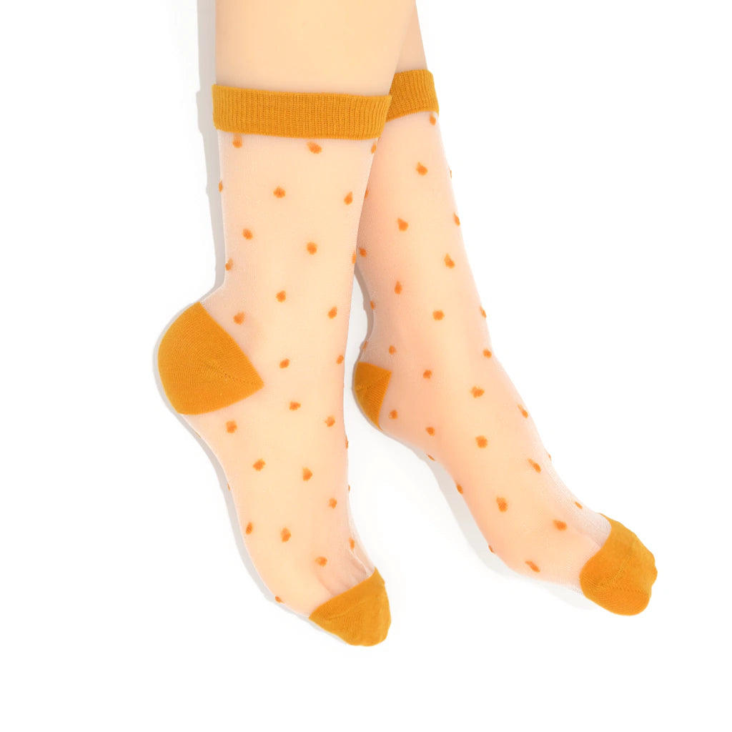 Sheer socks with mustard polka dots and cuffs on a white background
