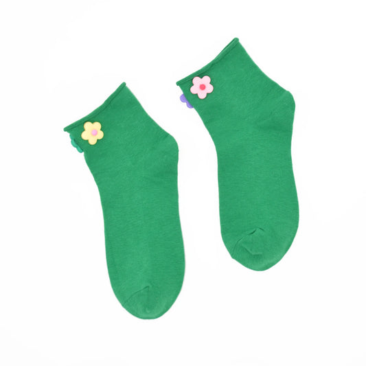Pair of green socks with flower decorations on a white background