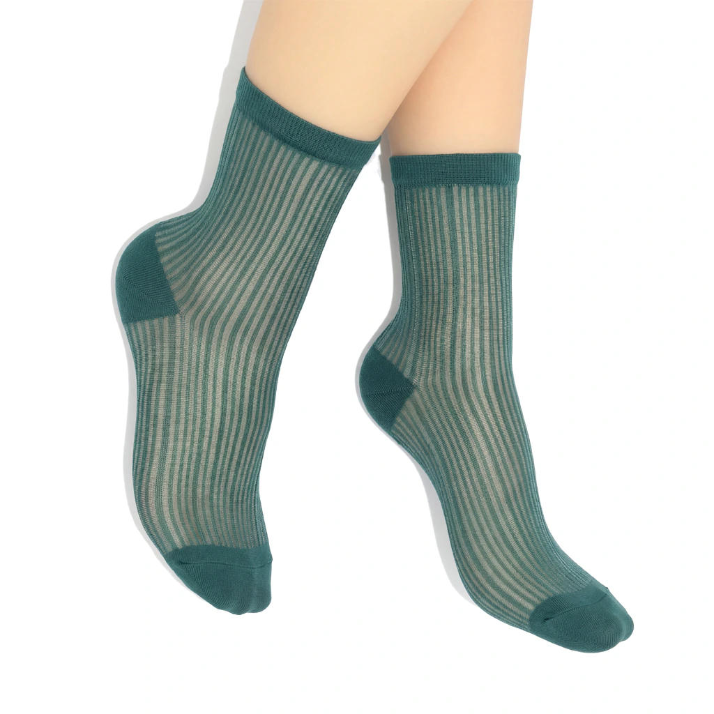 Green sheer socks worn by a person on a white background