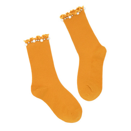 Pair of mustard yellow socks with pearl embellishment on a white background