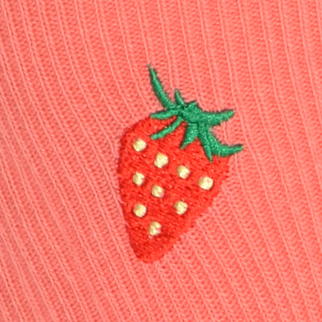 Embroidered strawberry design on a pink fabric background