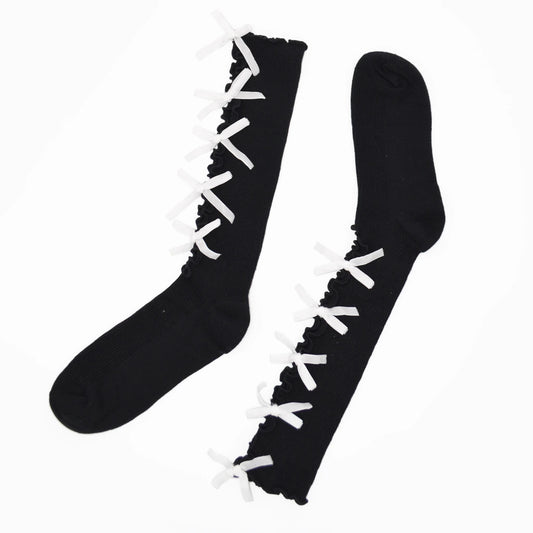 A pair of black knee-high socks with white lace-up detailing running up the front, displayed on a clean white background.