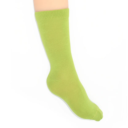 Leg modelling green socks on a white background