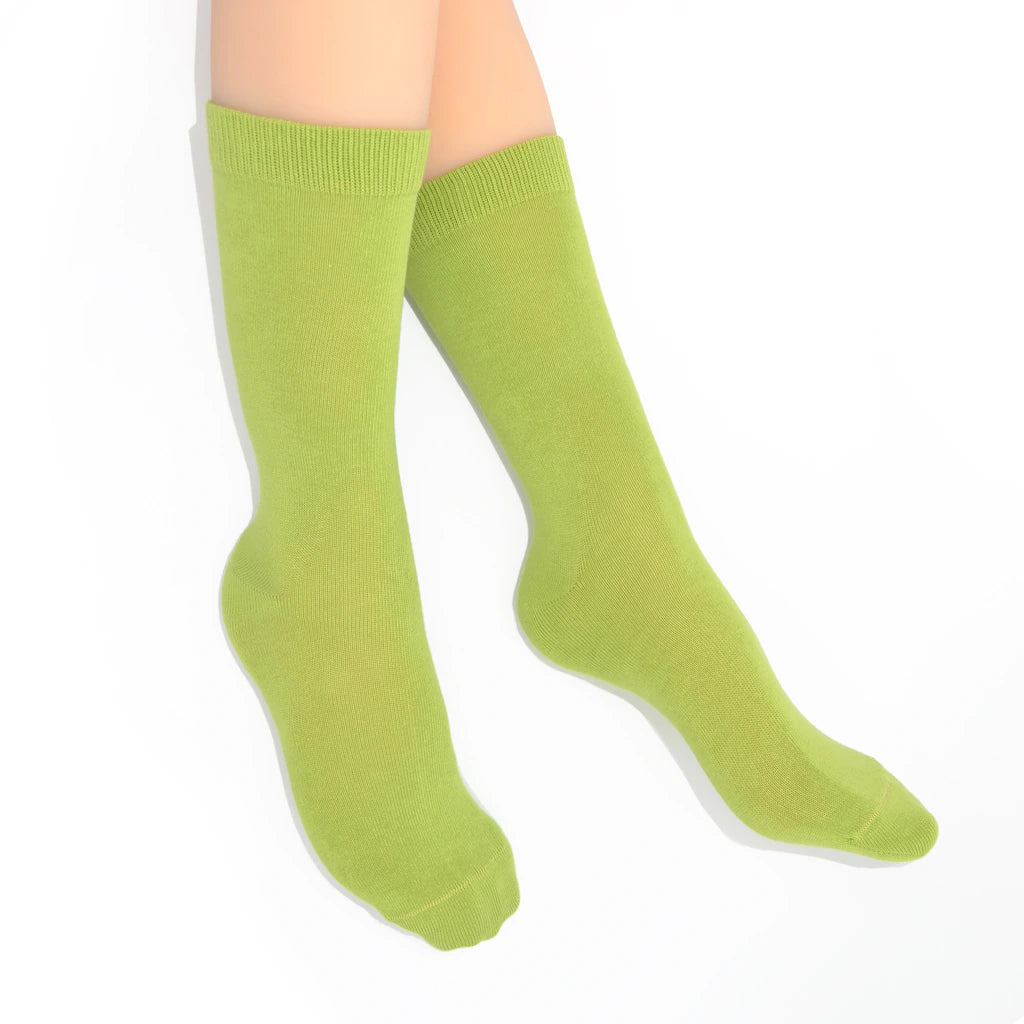 Legs modelling green socks on a white background