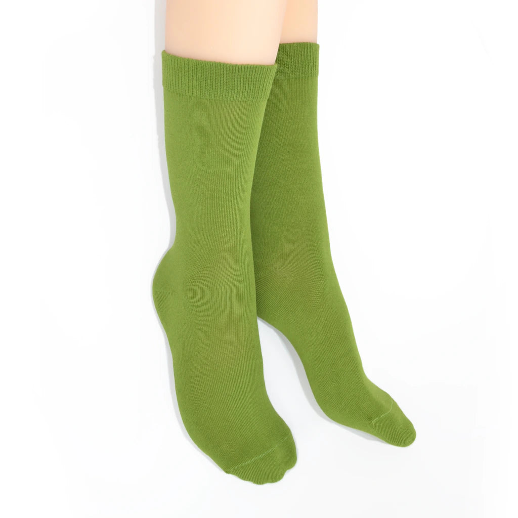 Legs modelling green socks on a white background