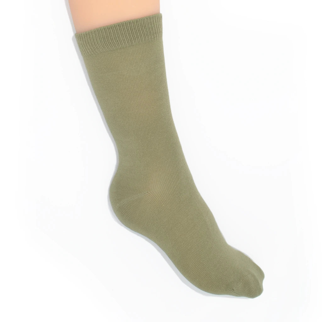 Leg modelling green socks on a white background