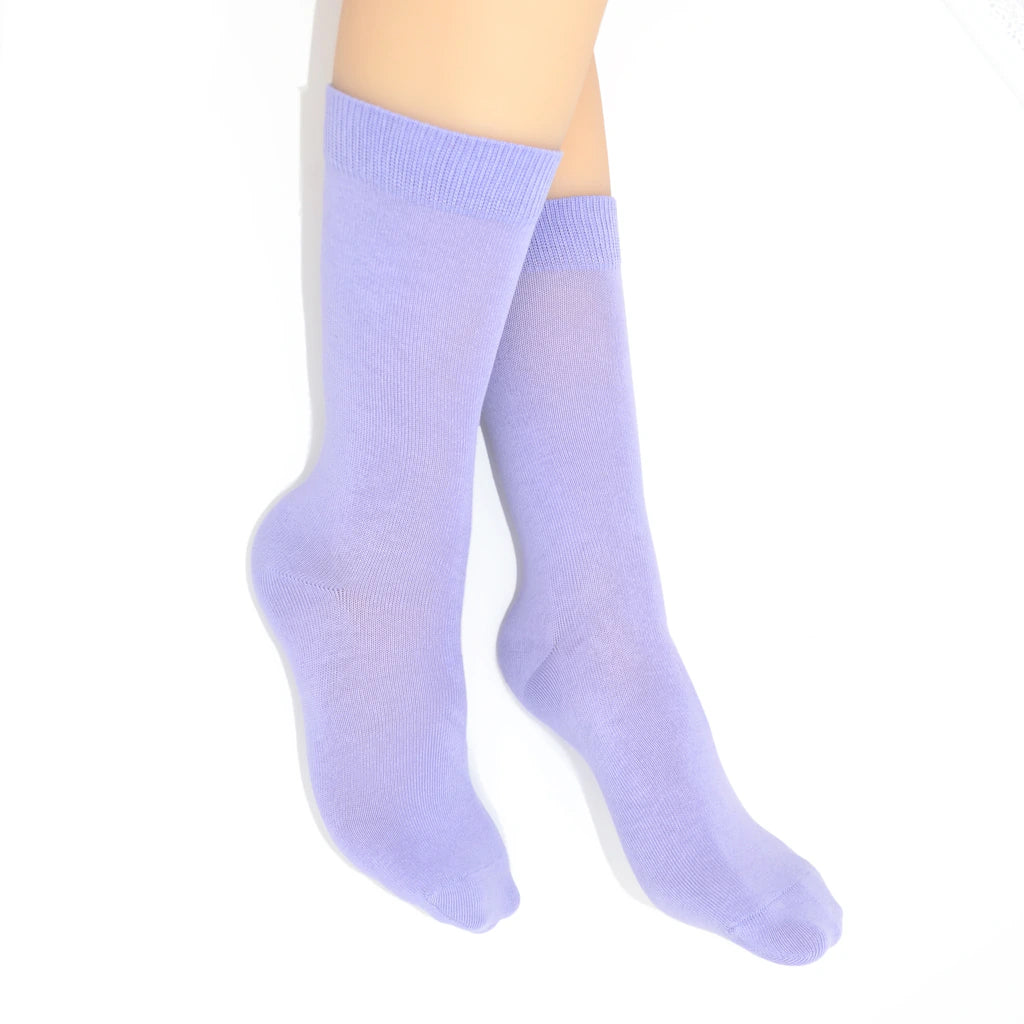 Legs modelling light purple socks on a white background