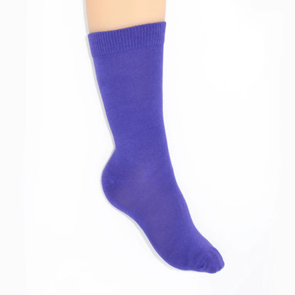 Leg modelling purple socks on a white background