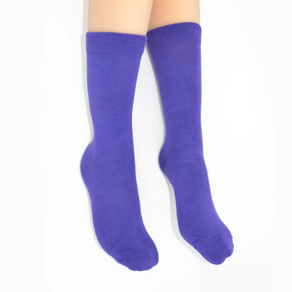 Legs modelling purple socks on a white background