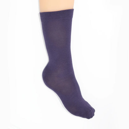 Leg modelling purple socks on a white background
