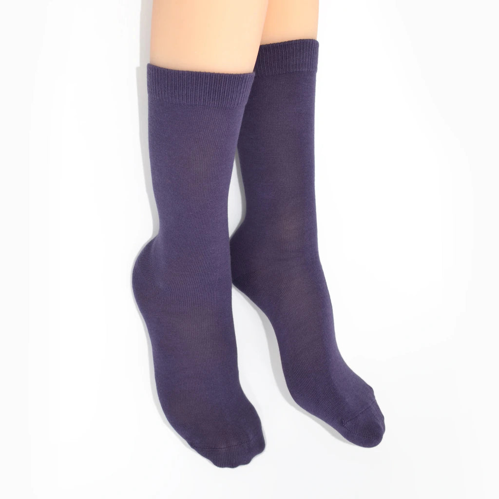 Legs modelling purple socks on a white background