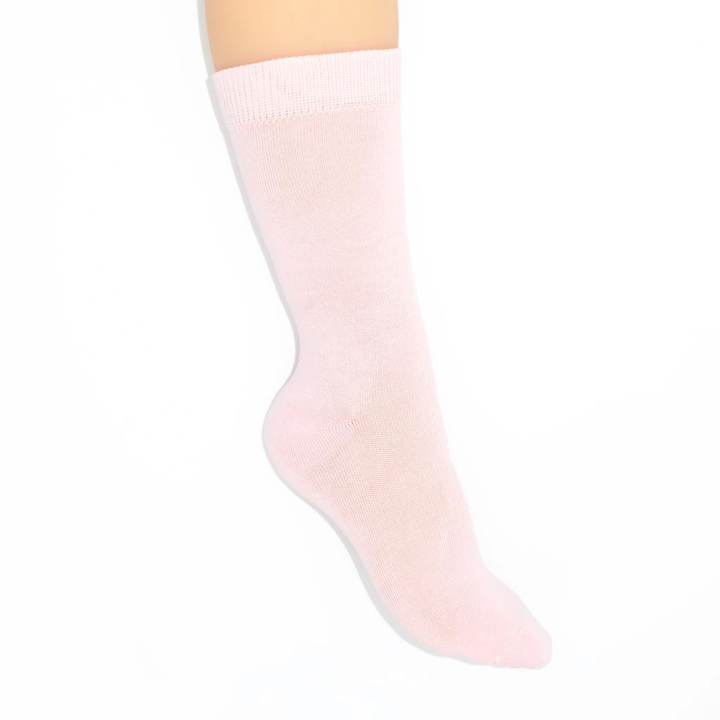 Leg modelling light pink socks on a white background