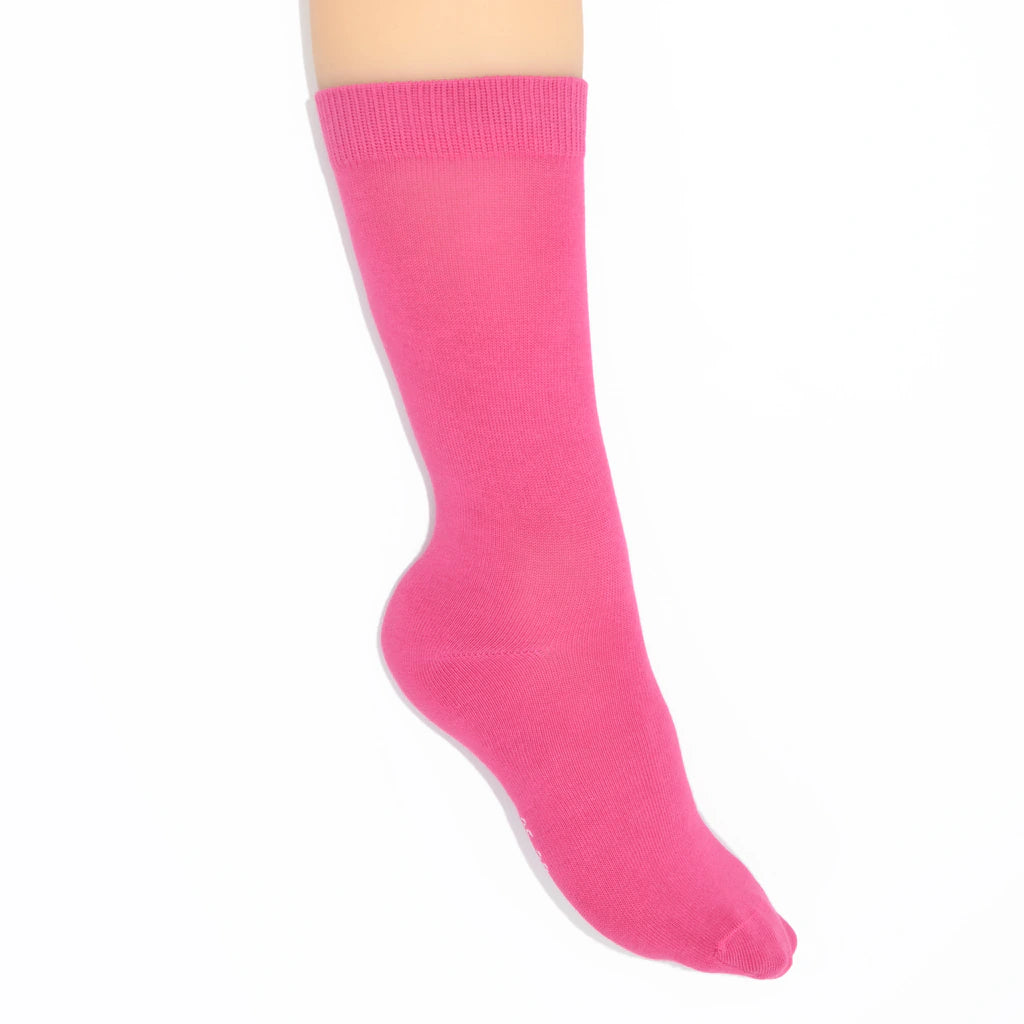 Leg modelling bright pink socks on a white background