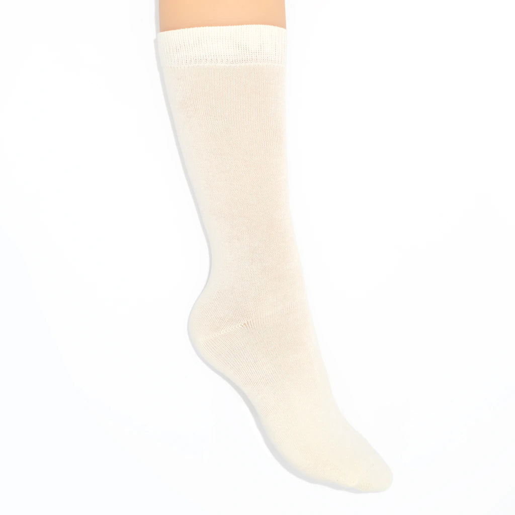 Leg modelling cream-colored socks on a white background
