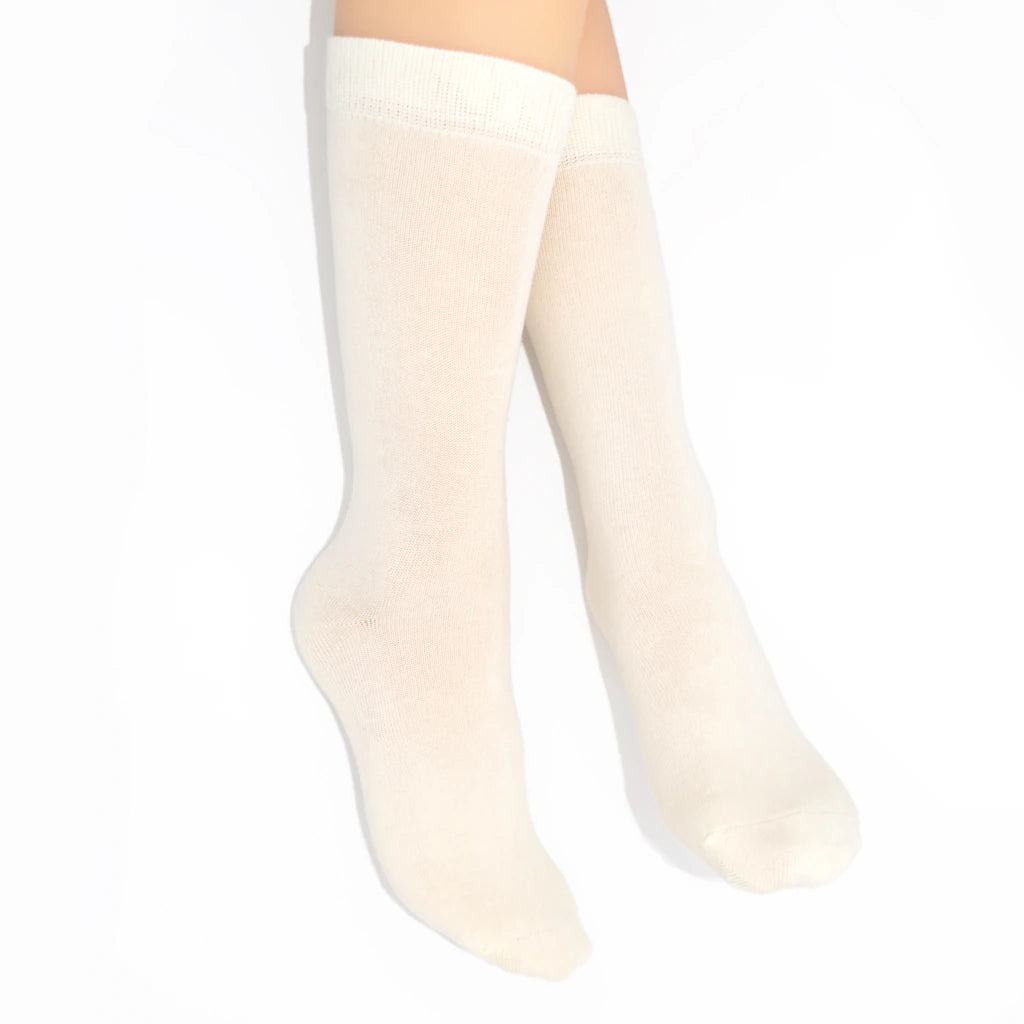 Legs modelling cream-colored socks on a white background