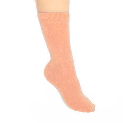 Leg modelling caramel coloured socks on a white background