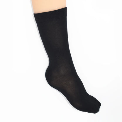 Leg modelling black socks on a white background