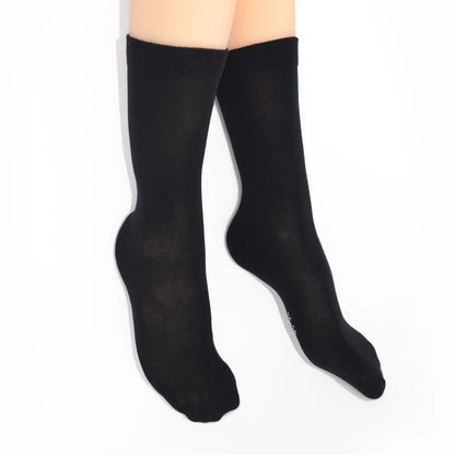 Legs modelling black socks on a white background