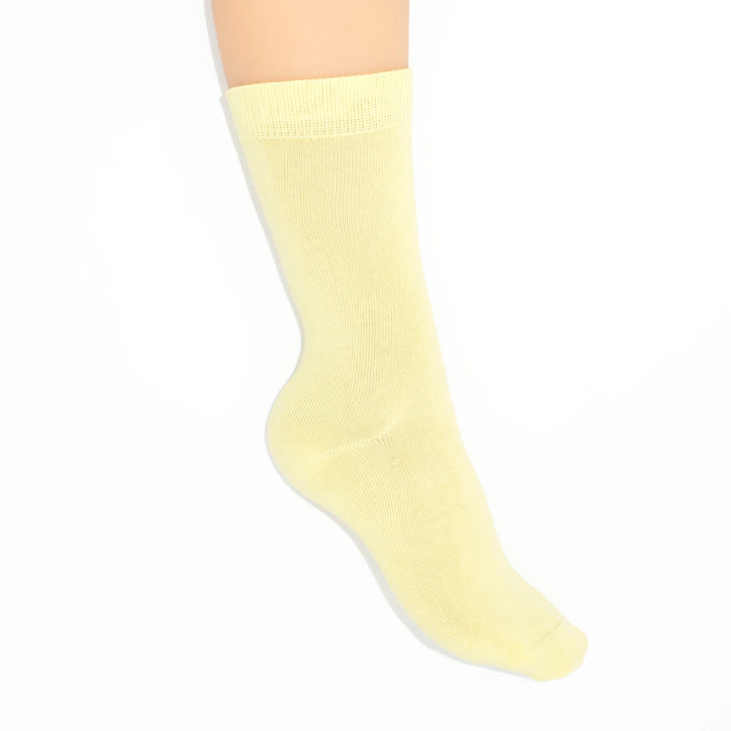 Leg modelling yellow socks on a white background