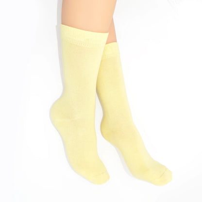 Legs modelling yellow socks on a white background