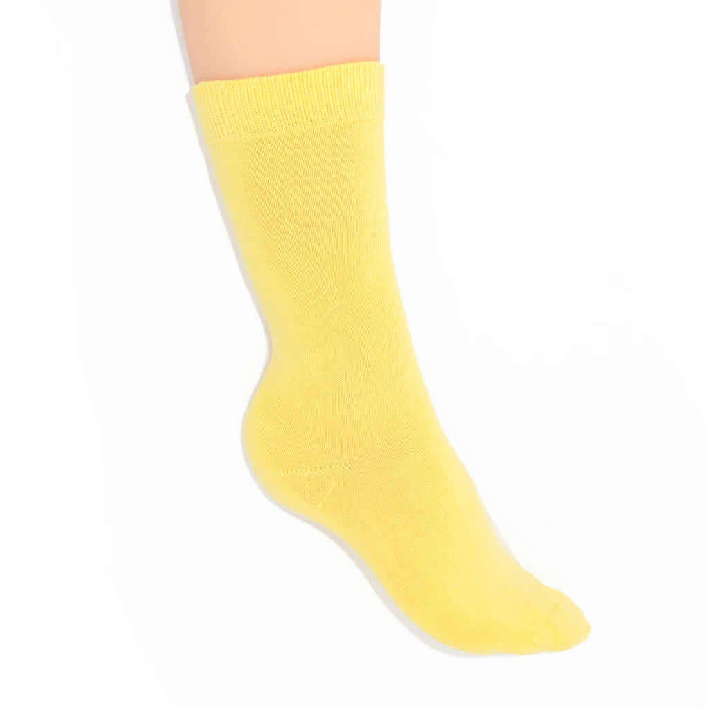 Leg modelling yellow socks on a white background