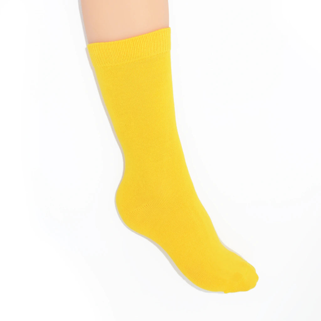 Leg modelling yellow socks on a white background