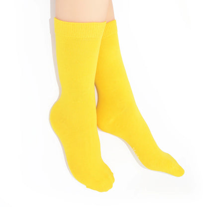 Legs modelling yellow socks on a white background