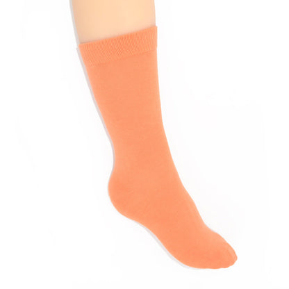 Leg modelling coral socks on a white background