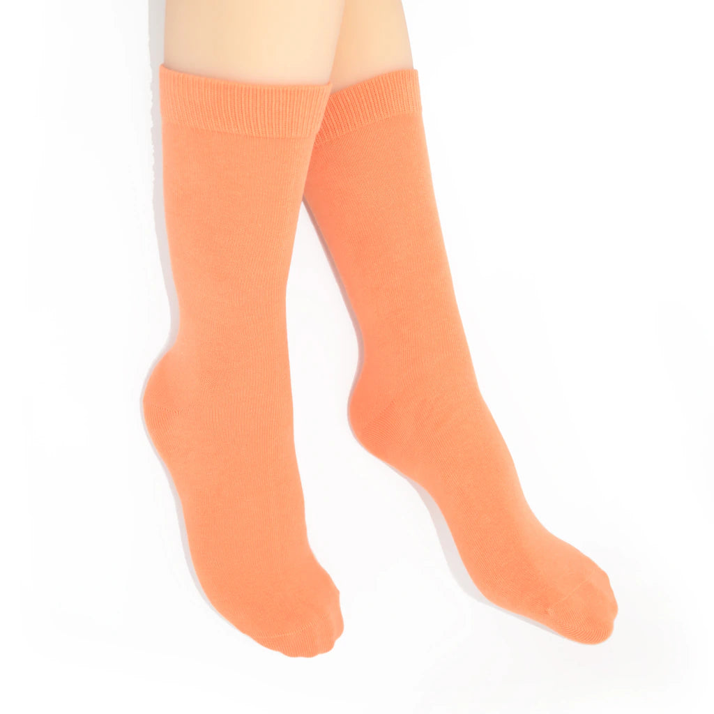 Legs modelling coral socks on a white background