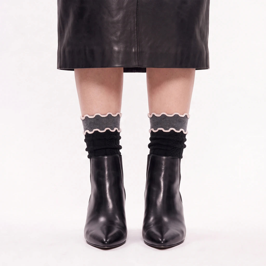 model wearing lettuce socks with black leather skirt and black leather boots