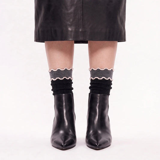 model wearing lettuce socks with black leather skirt and black leather boots
