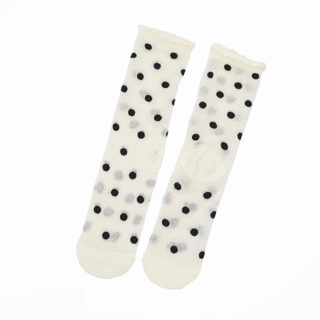 A pair of off-white sheer socks with black and light gray polka dots, displayed against a plain white background.