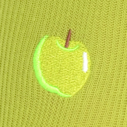 Green embroidered apple patch on a green fabric background