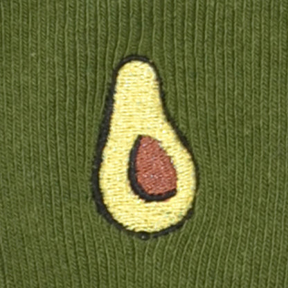 Embroidered avocado patch on a green fabric background
