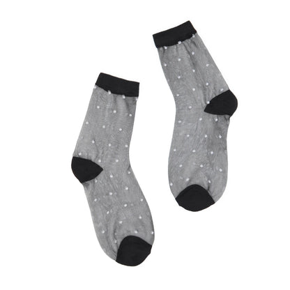 Sheer black socks with white dots, black cuffs and toes on a white background