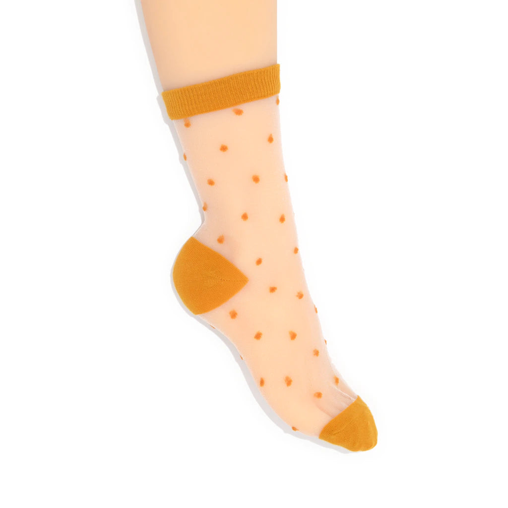 Sheer socks with mustard polka dots and cuffs on a white background