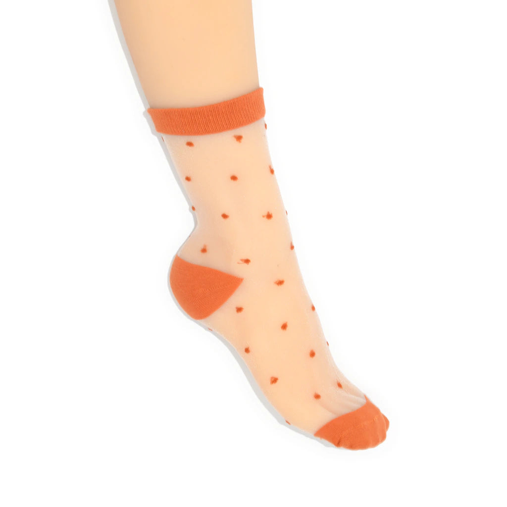 Sheer orange polka dot socks with solid orange toes and cuffs on a white background