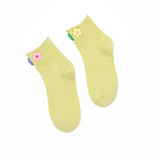 Pair of light green socks with colorful flower decorations on a white background