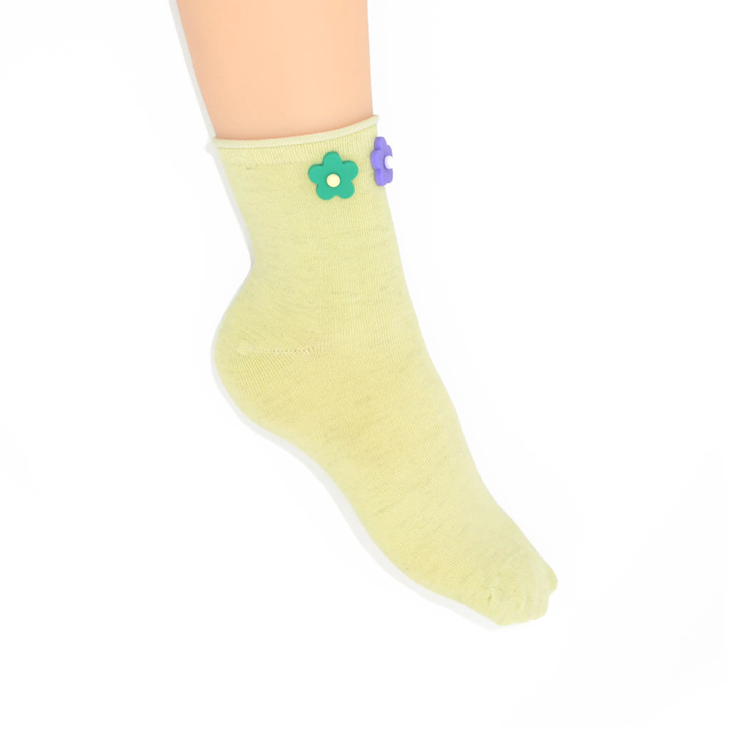 Light green sock with a flower design on a white background
