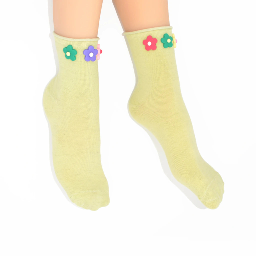 Light green socks with colorful flower decorations on a white background