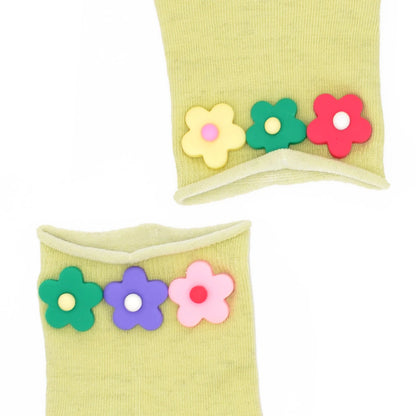 Yellow socks with colorful flower embellishments on a white background