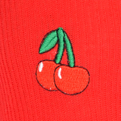 Embroidered cherries on a red fabric background