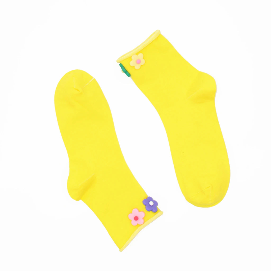 Yellow socks with colorful flower decorations on a white background