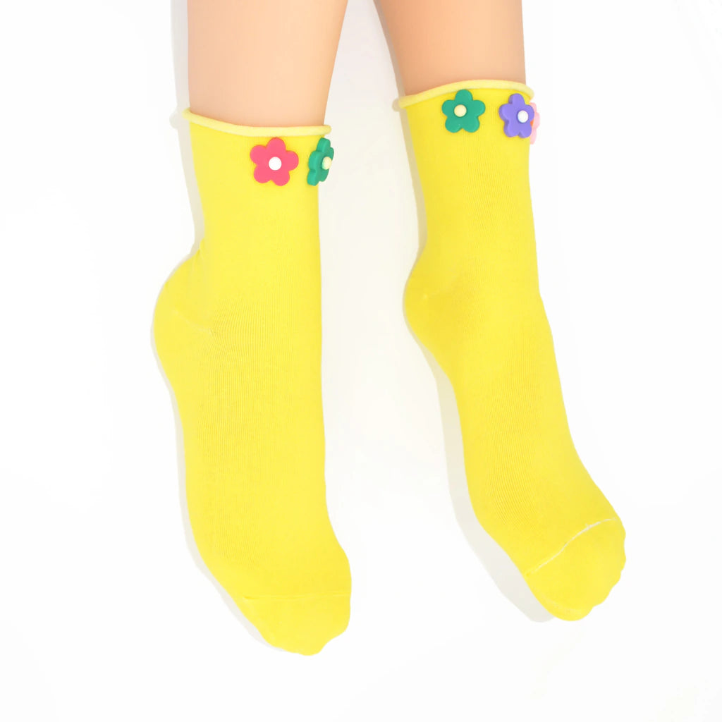 Yellow socks with colorful flower designs on a white background