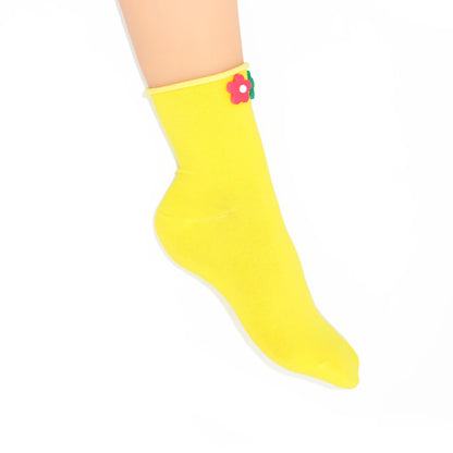 Yellow sock with a flower design on a white background
